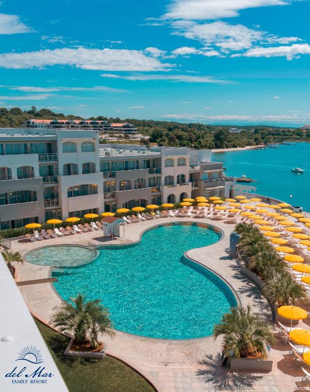 an outdoor swimming pool with chairs and umbrellas on a resort at Family Resort del Mar in Pula
