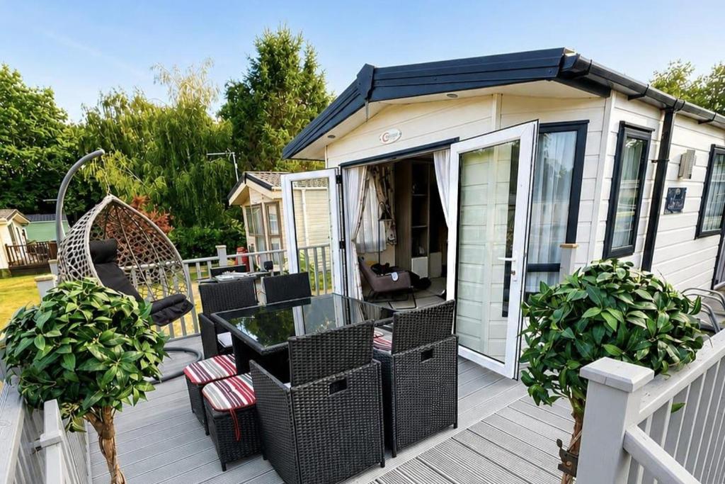 a patio with a table and chairs on a deck at StaticCaravan-6Berth-DogFriendly in Northampton