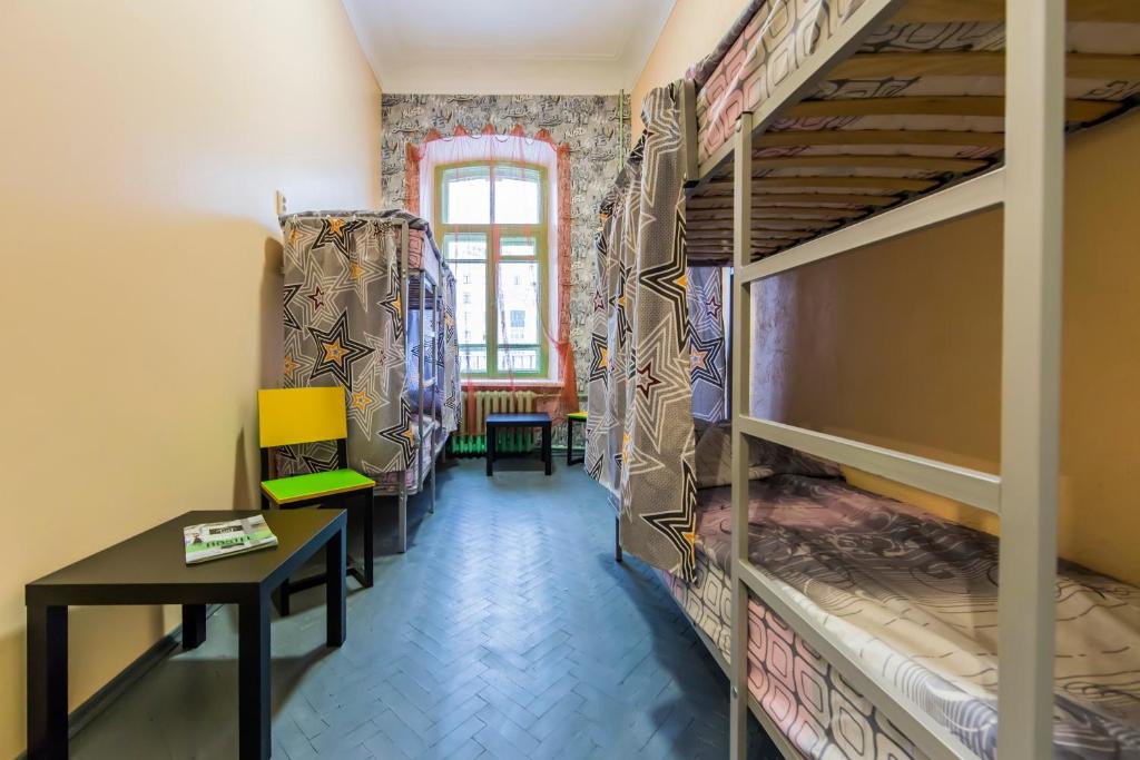 pokój z dwoma łóżkami piętrowymi i stołem w obiekcie Vorobey Hostel w Kijowie