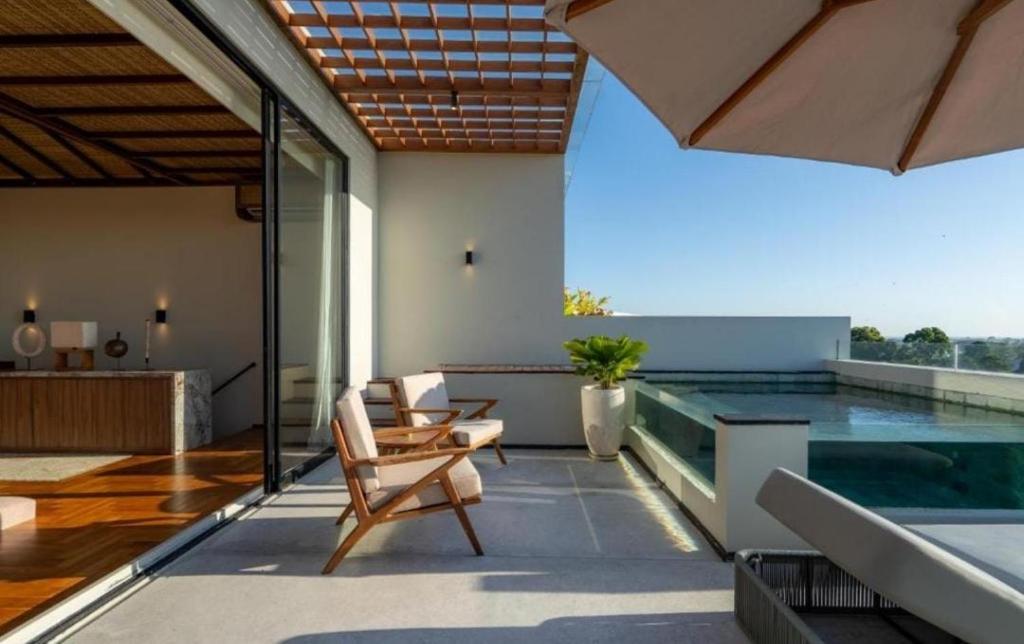 a patio with chairs and a swimming pool at Private room Canggu By SDM in Badung