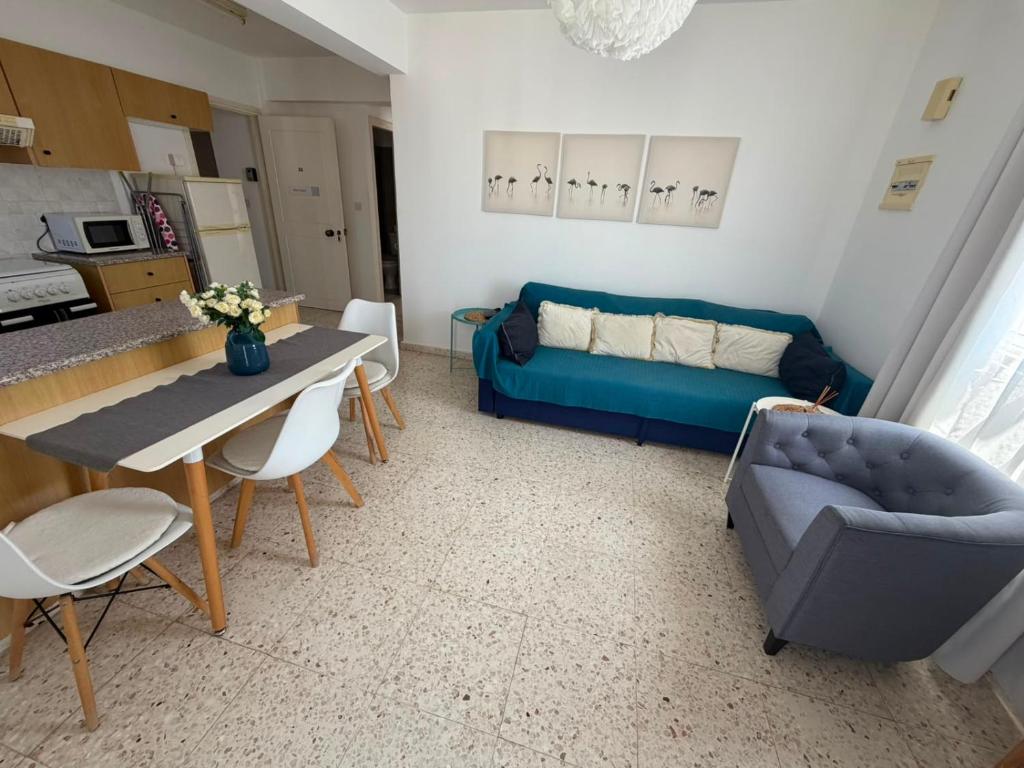 a living room with a blue couch and a table at Riana Latchi Apartment in Polis Chrysochous