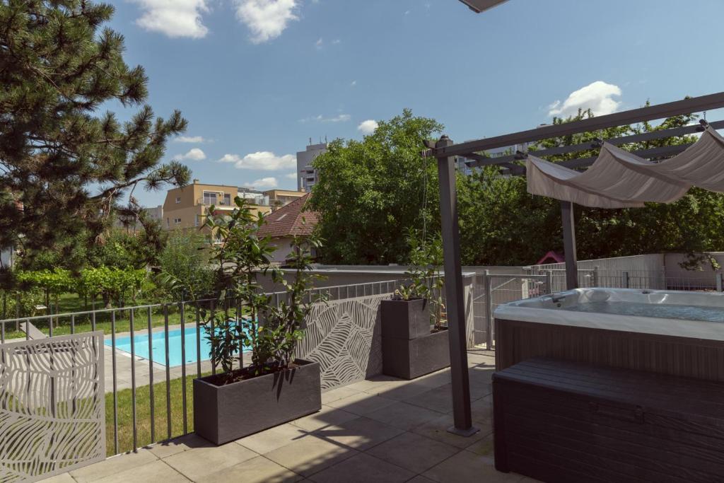 a hot tub on a patio next to a pool at Dream Getaway Apartment with Jacuzzi and Pool in Vienna