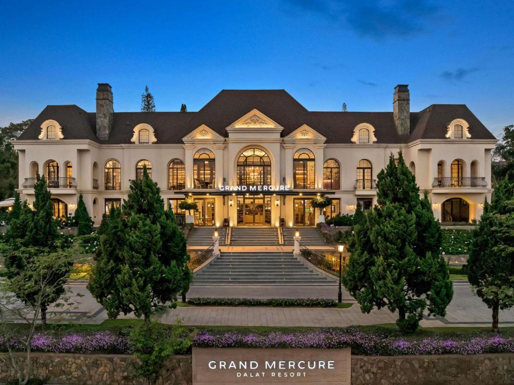a large white building with trees in front of it at Grand Mercure Dalat in Da Lat
