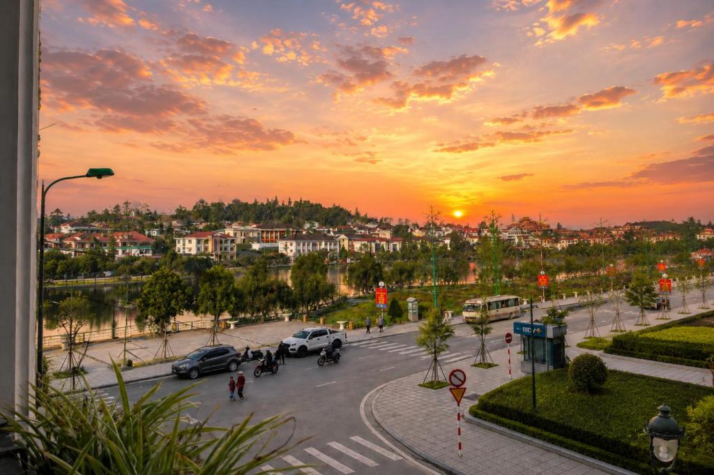 a city with cars parked on a street at sunset at Canvas Sapa Legend Hotel in Sapa