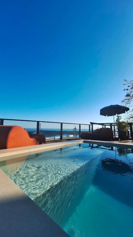 a swimming pool with a view of the ocean at Casatua Pousada in Juquei
