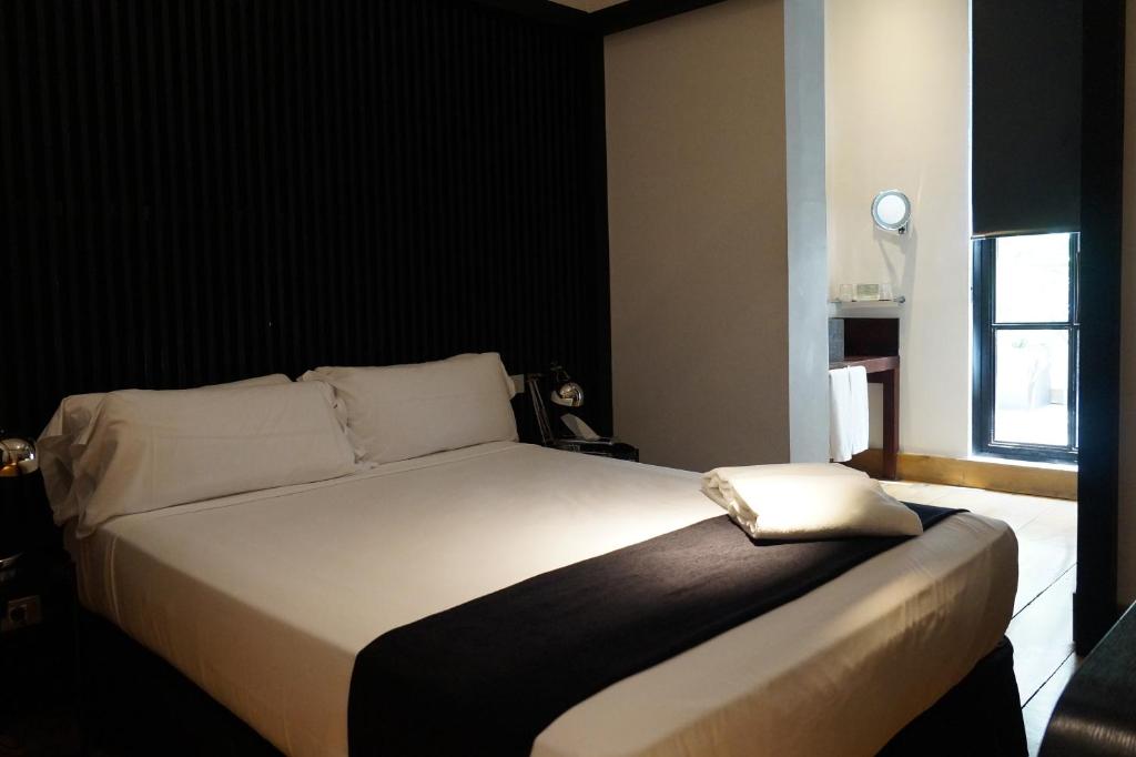 Ein Schlafzimmer mit einem weißen Bett und einer schwarzen Wand in der Unterkunft Hotel Market in Barcelona