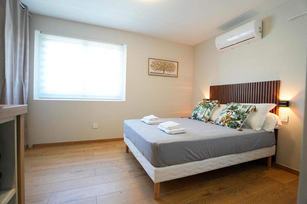 a bedroom with a large bed with a window at Studio S Les Suites Du Roubion in Montélimar
