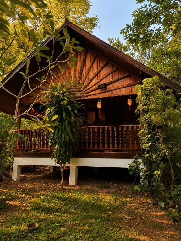 a large wooden cabin with a porch and a tree at Thai house in Chaweng in Nathon Bay
