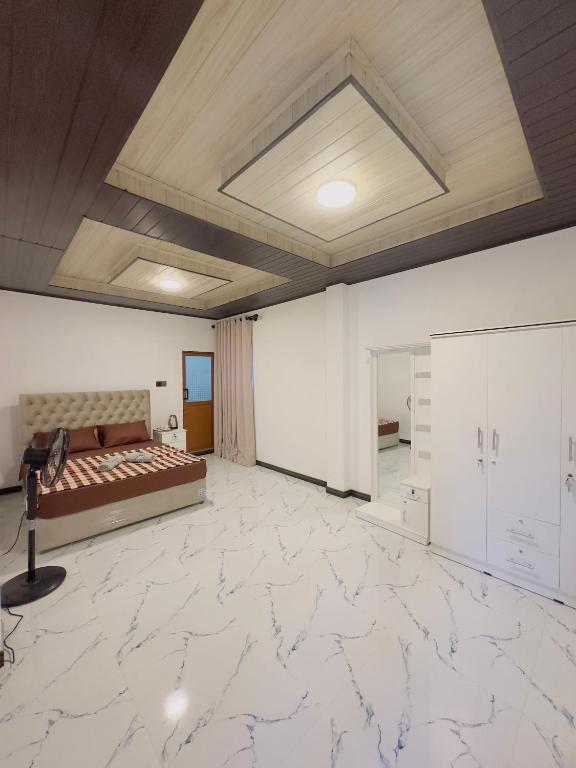 a large room with a bed and white marble floors at Misty Garden in Maskeliya
