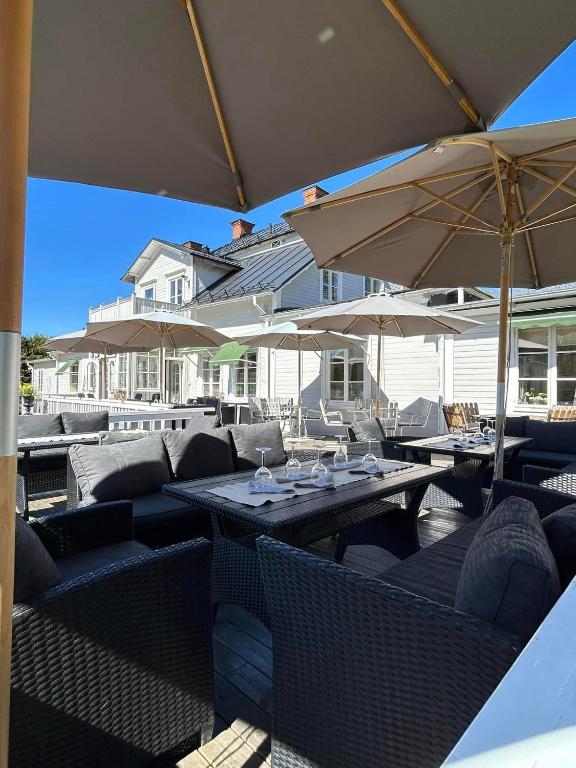 a patio with tables and chairs and umbrellas at Wanbo Herrgård in Nedre Vanbo