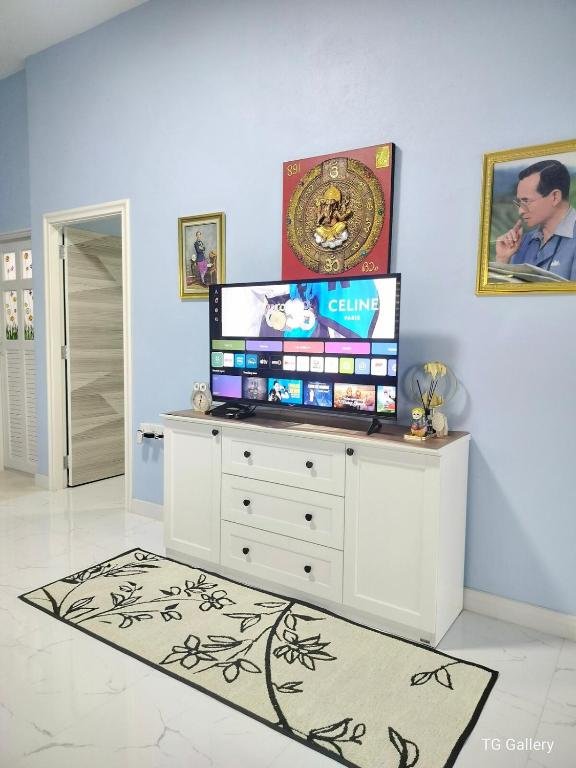 a living room with a tv on a white dresser at Aura Home Kalasin in Kalasin