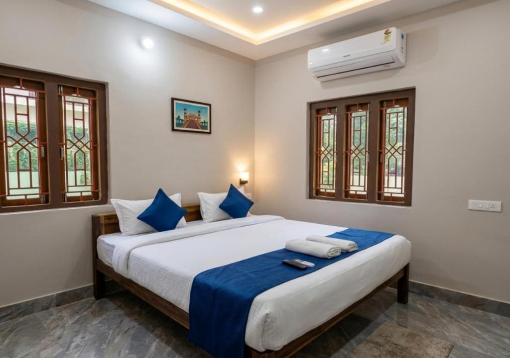 a bedroom with a large bed with blue pillows at Das & Das Hotel in Bhubaneshwar