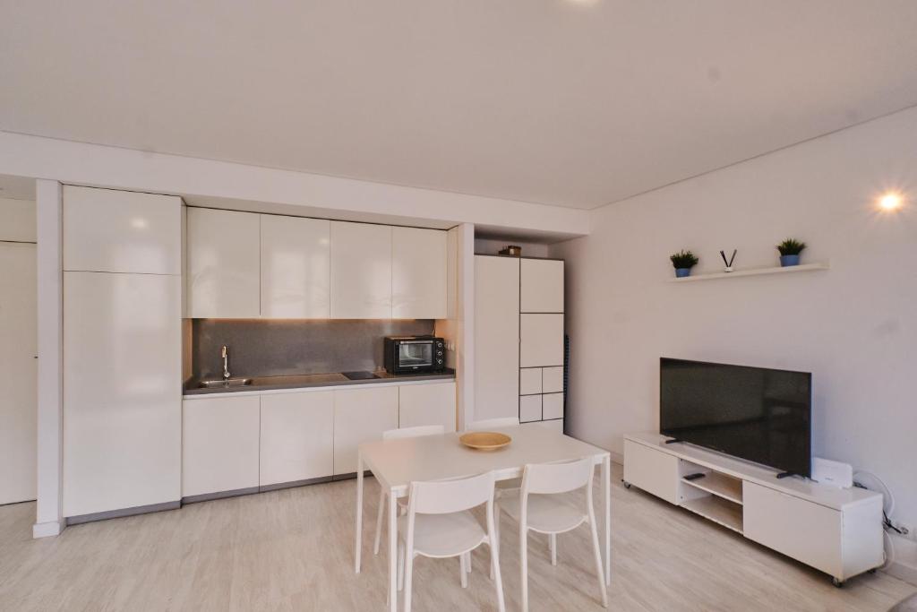 a kitchen with white cabinets and a table and chairs at Aeropuerto loft 8 by Azahar Stay in Manises