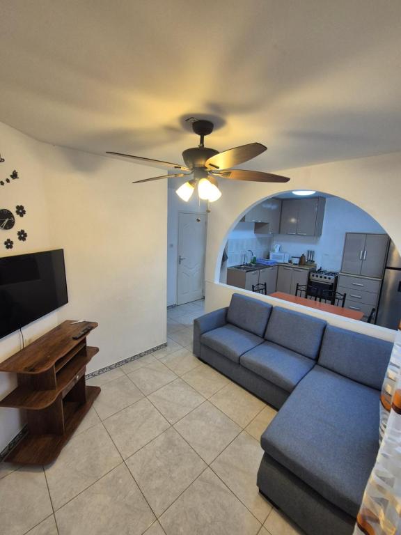 a living room with a couch and a ceiling fan at Sterappel Sun Stay in Paramaribo
