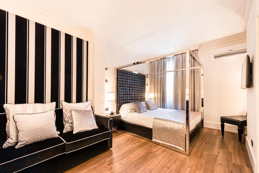 ヴェローナにあるヴェローナ ハウス アパートホテルのベッドルーム(ベッド1台、ソファ付)