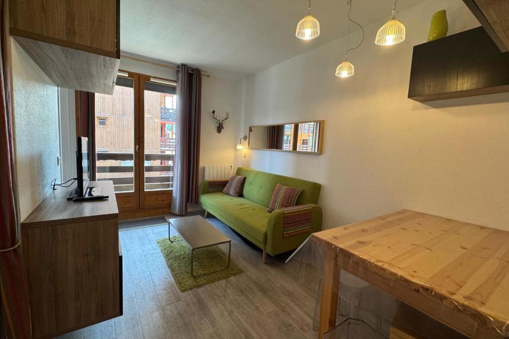 a living room with a green couch and a table at Appart T2 pers Risoul Proche pistes in Risoul
