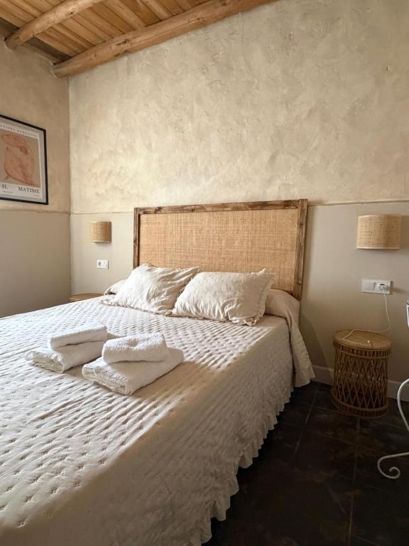 a bedroom with a white bed with towels on it at Casa Limón in Bodonal de la Sierra