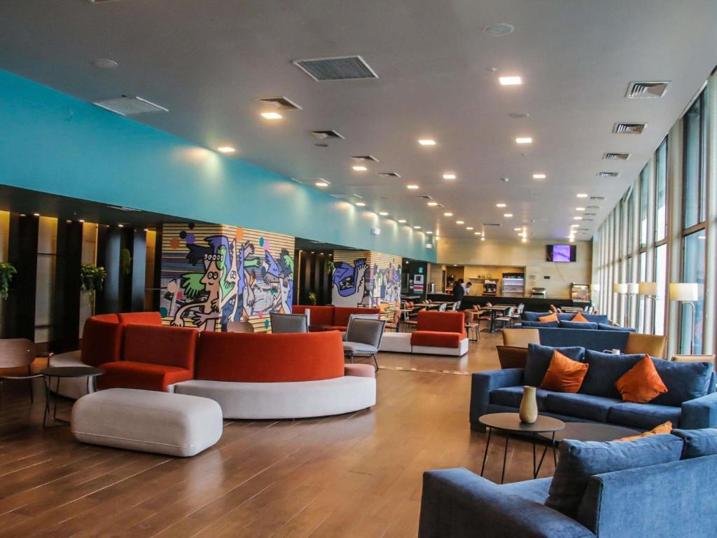 a lobby with couches and chairs in a building at Novotel Puerto Montt in Puerto Montt
