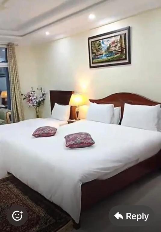 a bedroom with a large white bed with two pillows at Woodford Ayubia in Ayubia