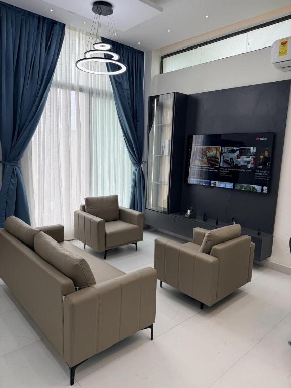 a living room with two couches and a flat screen tv at Nana's Villa in Danfa