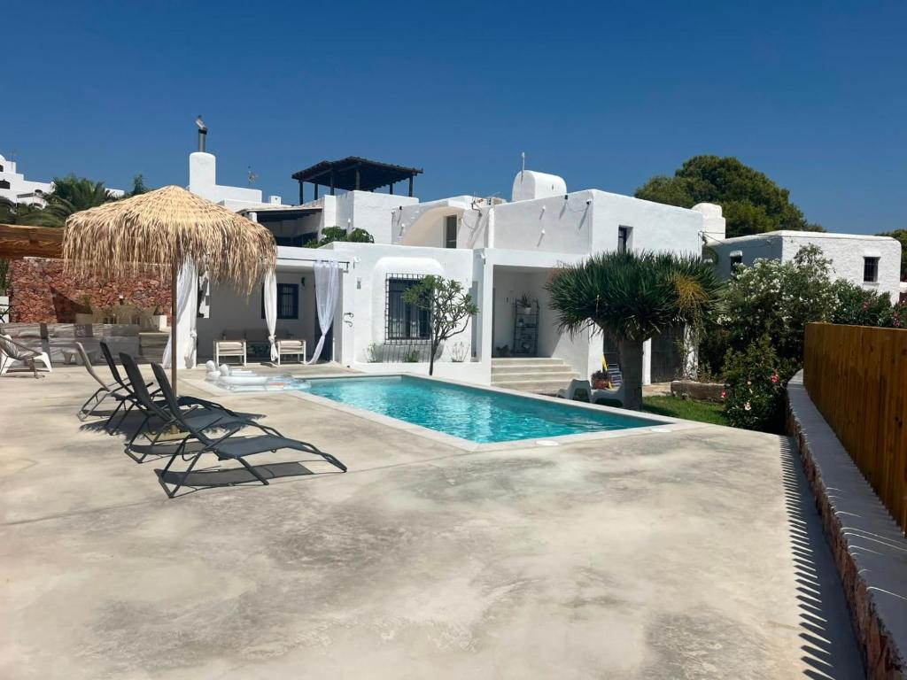 a villa with a swimming pool in front of a house at CASA PIZZI in Agua Amarga