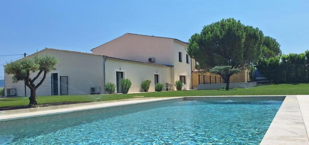 a house and a swimming pool in front of a house at L'Arcadia Chambres d'hôtes près de Vaison la Romaine et Mont Ventoux à Crestet in Crestet
