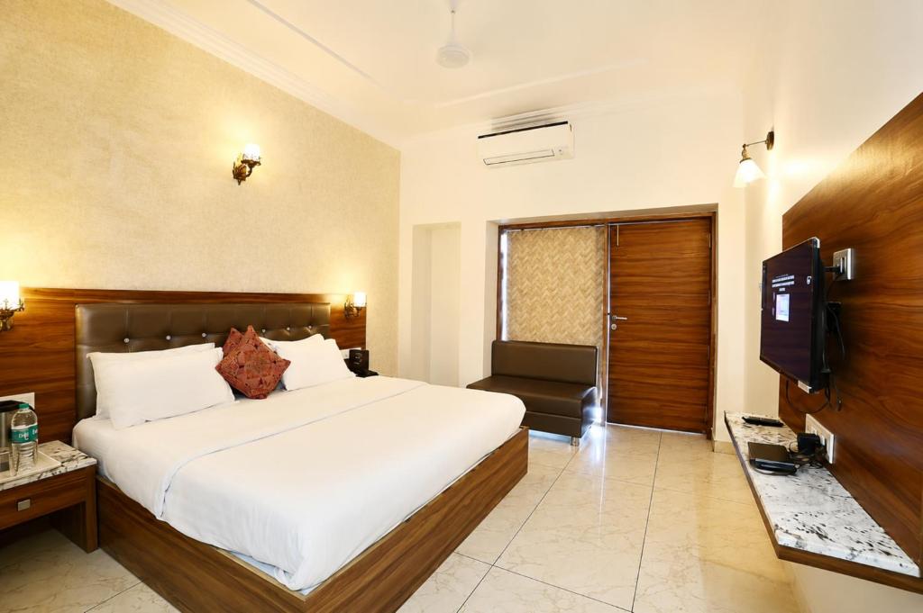 a hotel room with a bed and a television at Hotel Aradhana In Mount Abu in Mount Ābu