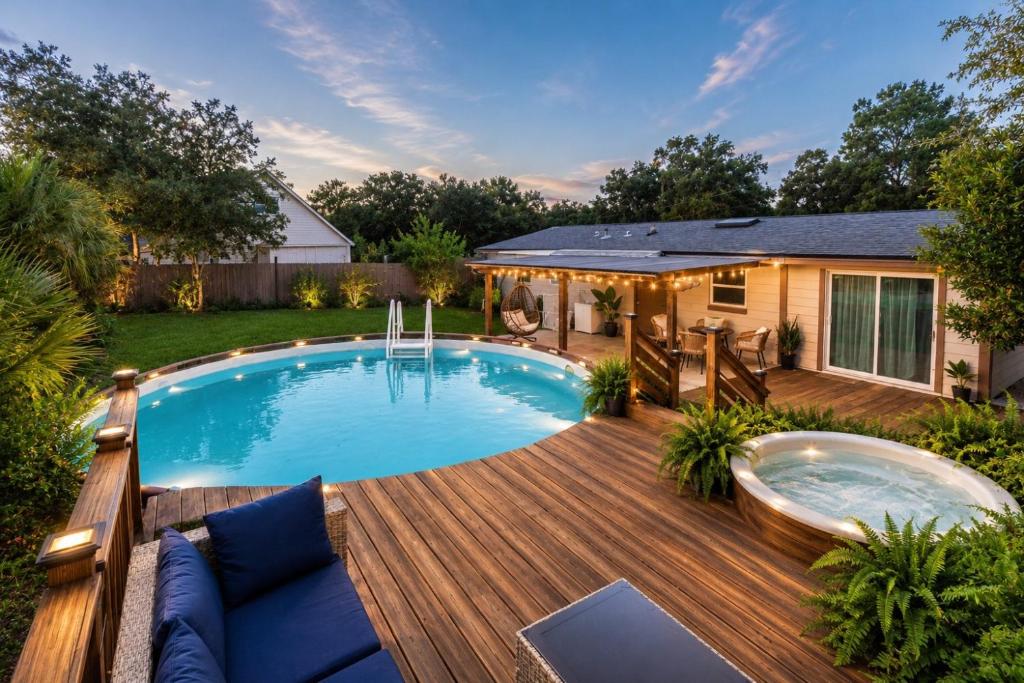a backyard pool with a wooden deck and a swimming pool at Private Pool, Hot Tub & Game Room Retreat in Jacksonville