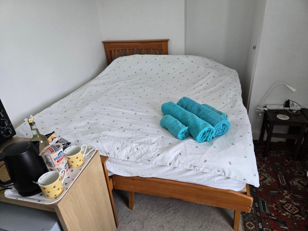 a bed with two blue folded towels on it at BEE KIND available with shared bathroom in Glastonbury