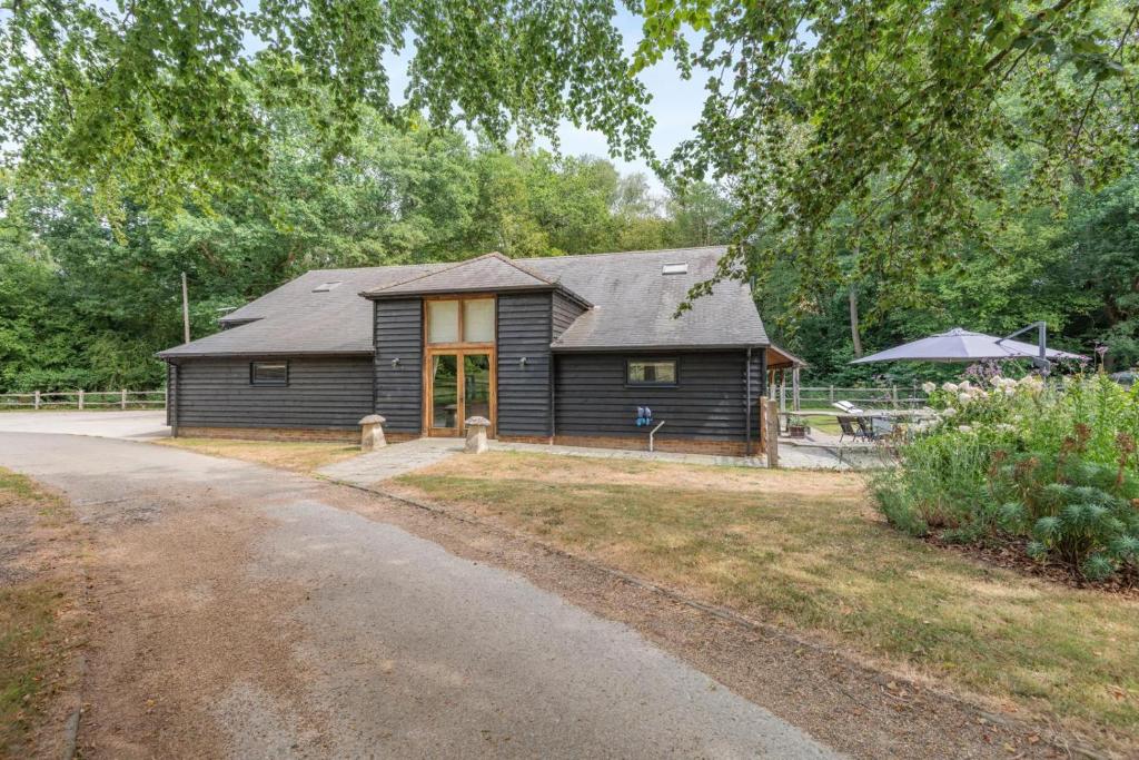 a wooden house with a porch and a driveway at 4 Bed in Ewhurst Green oc-w31032 in Hurst Green