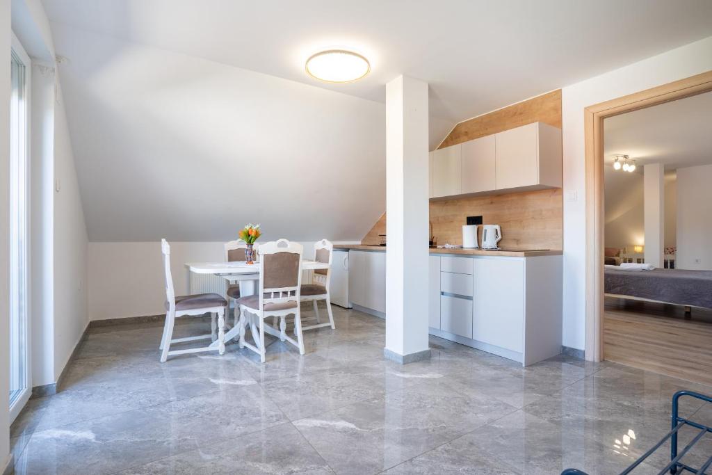 kuchnia i jadalnia ze stołem i krzesłami w obiekcie Guesthouse Viktorija Flat - Deluxe Apartment w mieście Otočac