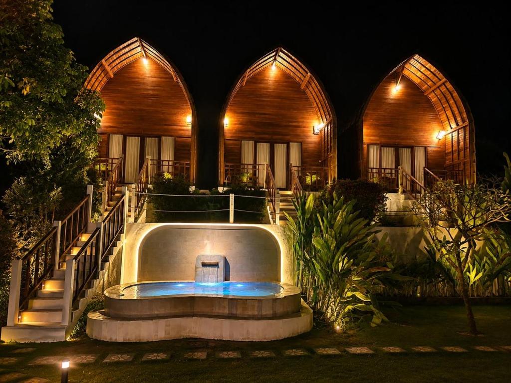 a resort with a hot tub in front of a building at Lake Batur Cottage in Bangli