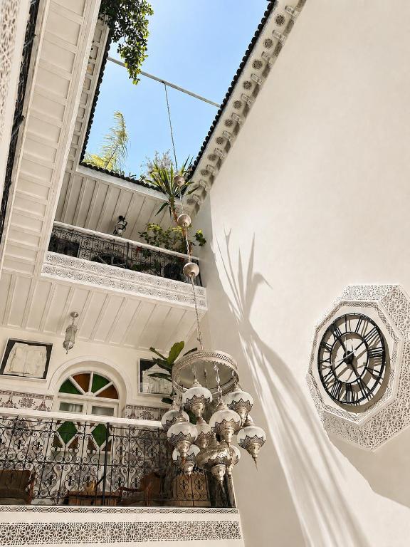 a clock on the side of a building with a balcony at Riad Darabi l Private Medina Home in Marrakesh