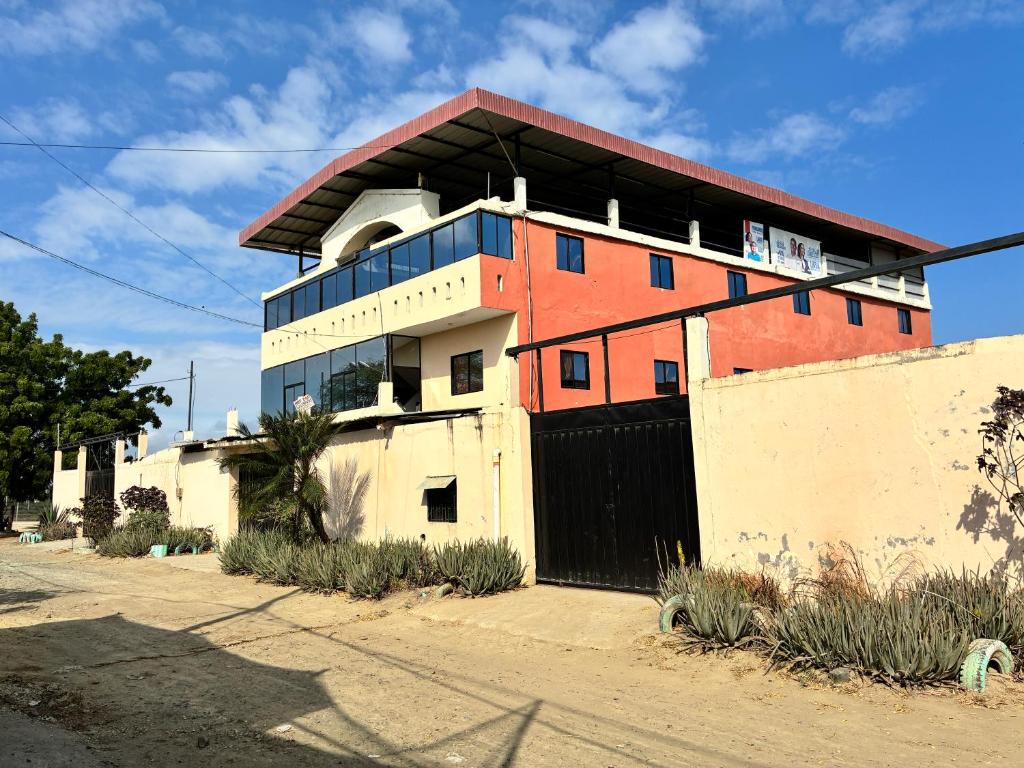 a building with a fence in front of it at Auto Hostal Jaramisol in Jaramijó