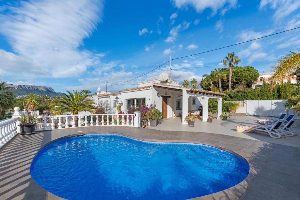 a swimming pool in front of a house at Villa Baobab - Plusholidays in Ifach
