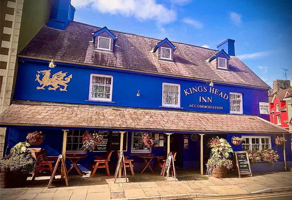 a blue building with tables and chairs in front of it at The Kings Head Inn in Llandovery