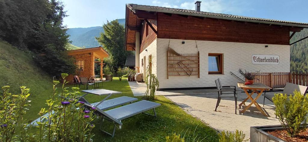 a cottage with a patio and a table and chairs at Schartenblick in Sarntal