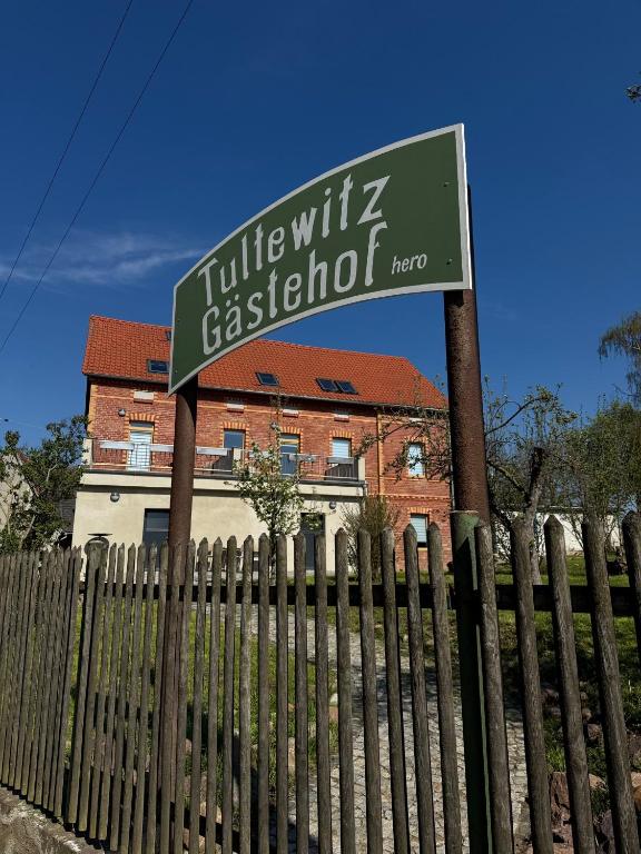 a green street sign in front of a fence at Gästehof Tultewitz in Naumburg