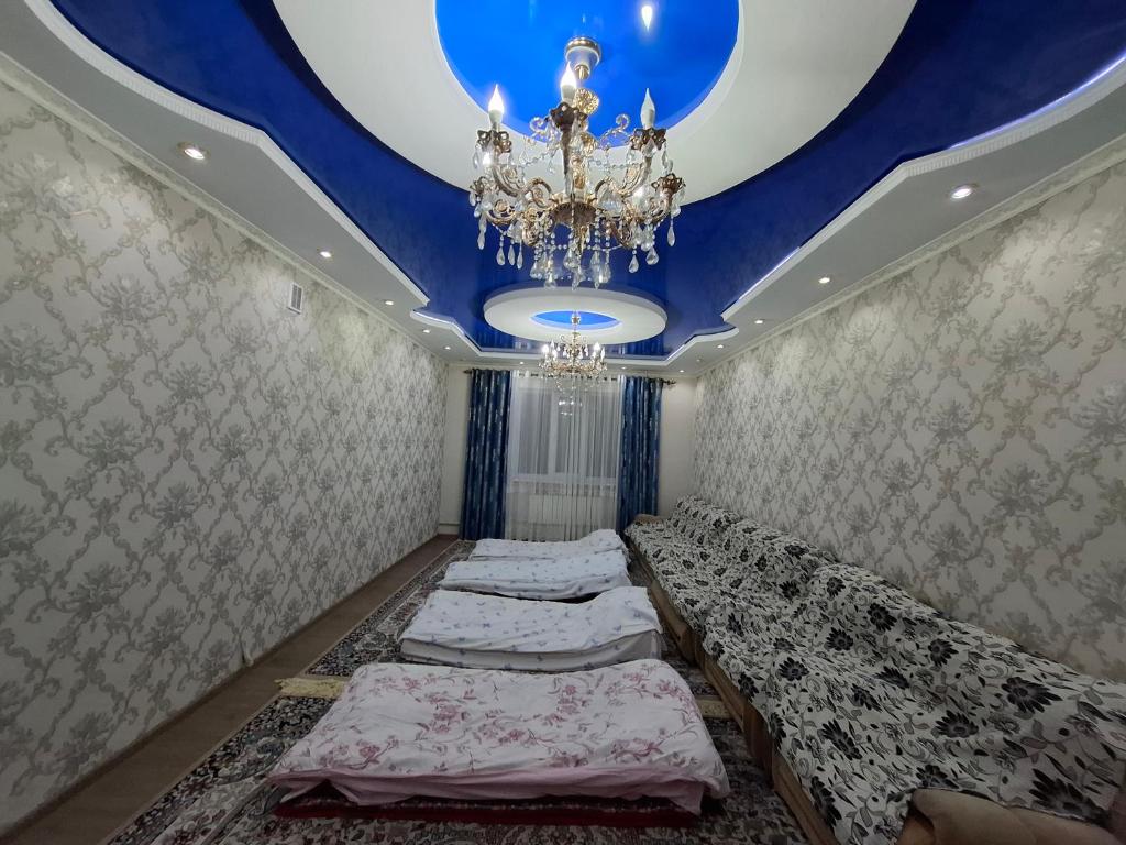 a bedroom with a blue ceiling and a chandelier at Aihan guest house in Pokrovka
