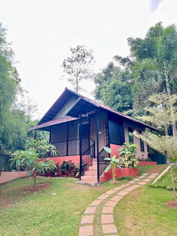 a house with a pathway in front of it at Wayanad Way Resort in Koroth