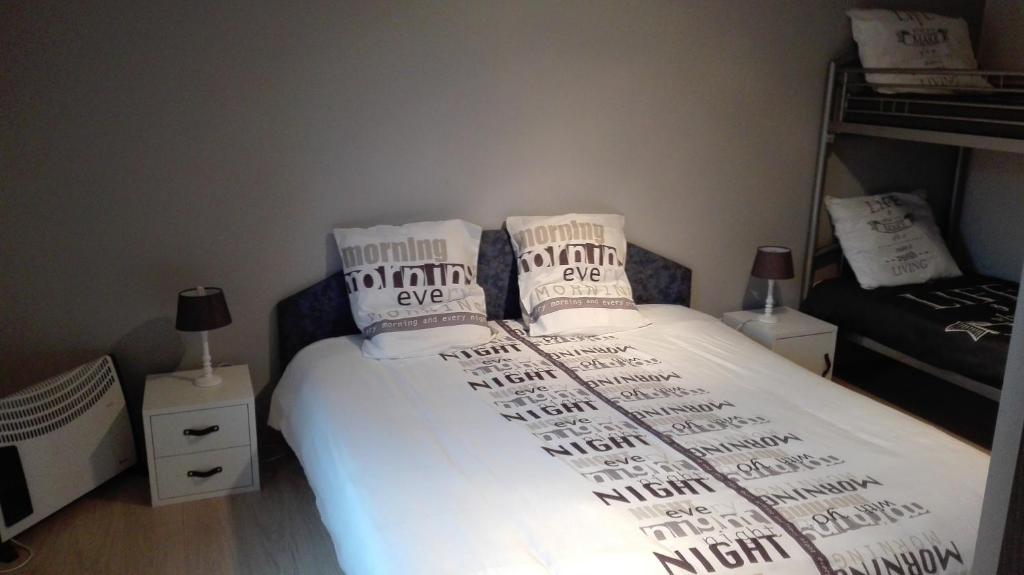 una camera da letto con letto, lenzuola e cuscini bianchi di Aux doux rêves a Provèdroux