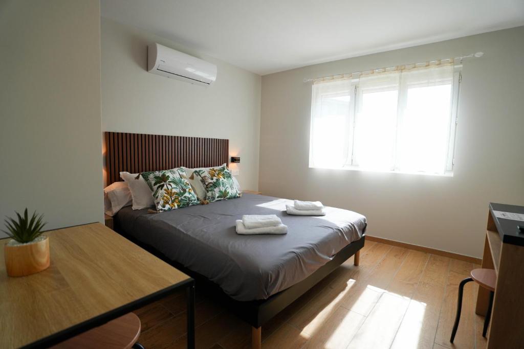 a bedroom with a bed with two towels on it at Studio M Les Suites Du Roubion in Montélimar