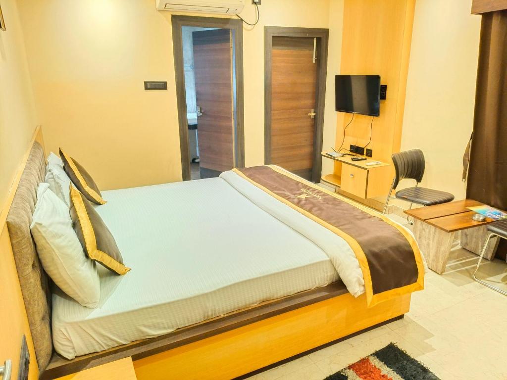 a bedroom with a bed and a tv in a room at NAKSHATRA Hotel, Restaurant & Banquet in Barddhamān