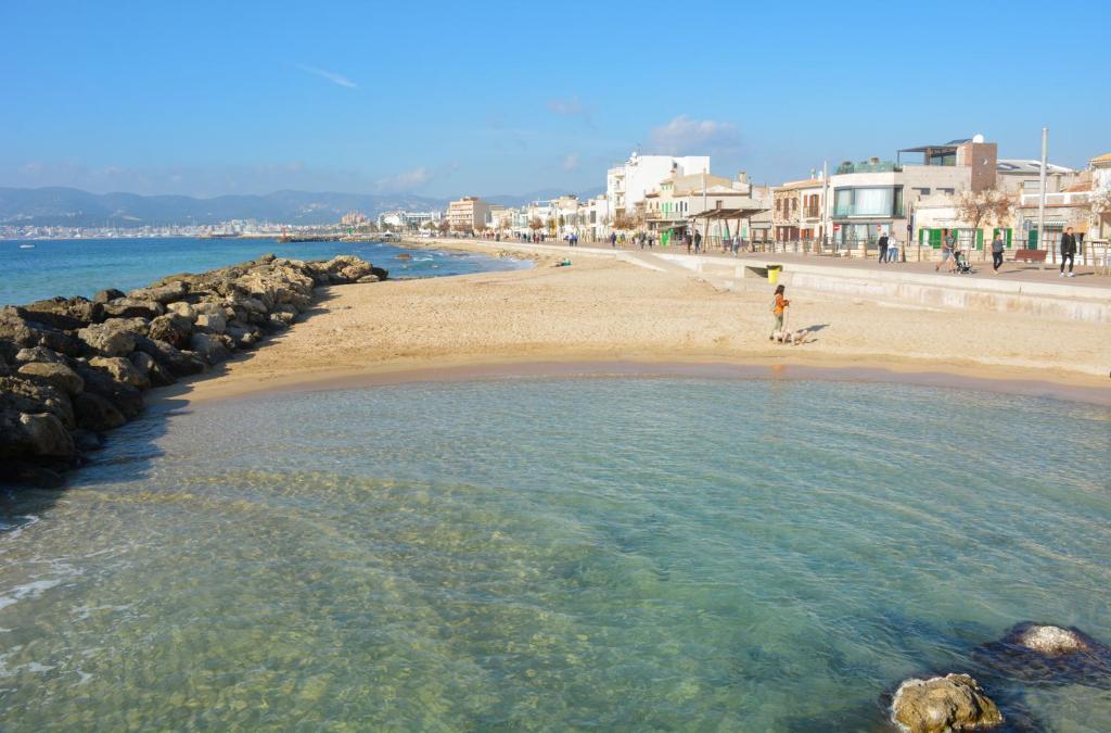 une personne debout dans l'eau sur une plage dans l'établissement 28 Townhouse 200mts from sea/beach, à Palma de Majorque