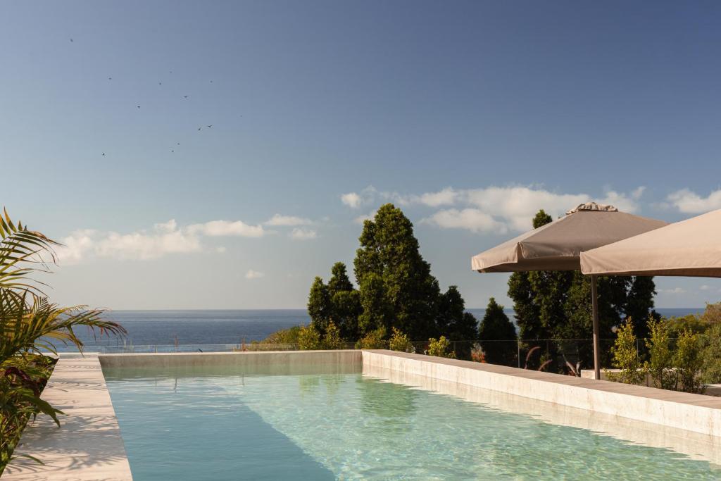 a swimming pool with a view of the ocean at Moon & Sun Funchal in Funchal