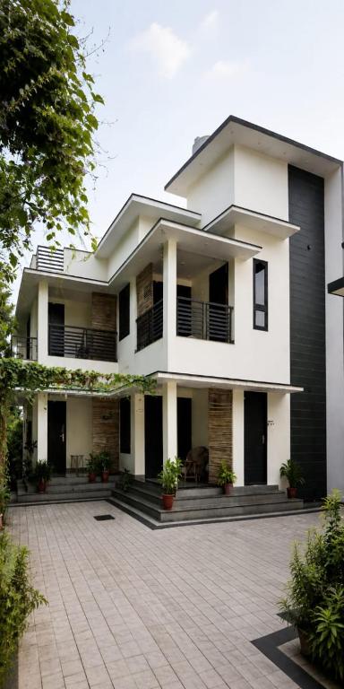 a large white house with a courtyard in front of it at Varkala Days Home Stay in Varkala