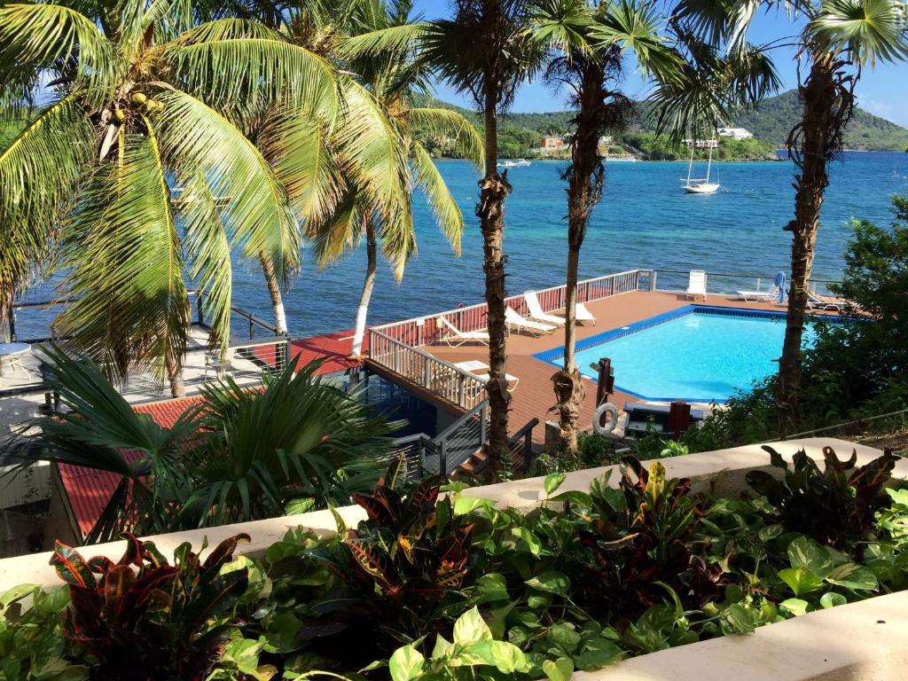 a swimming pool with palm trees and a body of water at Point Pleasant Resort® 1BR Suite with Ocean Views in Nazareth