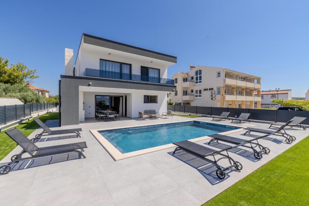 a villa with a swimming pool and a house at Villa Josip in Sukošan