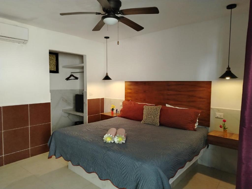 a bedroom with a bed with flowers and a ceiling fan at Hotel La Casa del Capi in Holbox Island