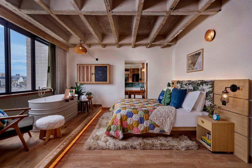 a bedroom with a bed and a bath tub next to a bed sidx sidx sidx at Treehouse Hotel Manchester in Manchester